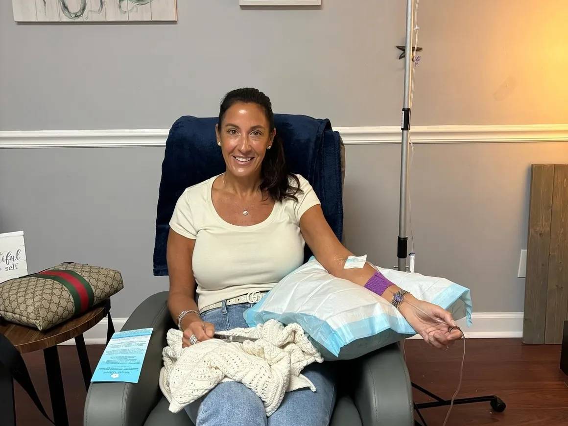 Woman receiving IV therapy in a chair.