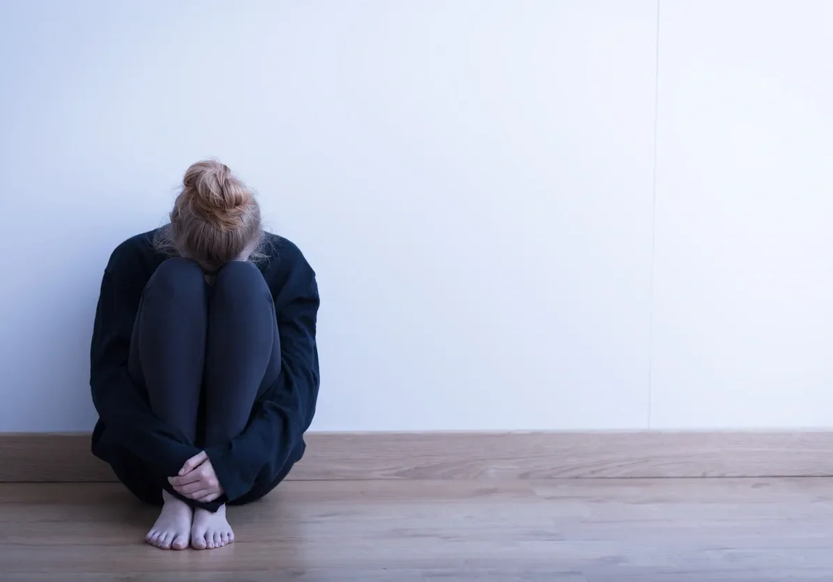 Person sitting alone in a corner.